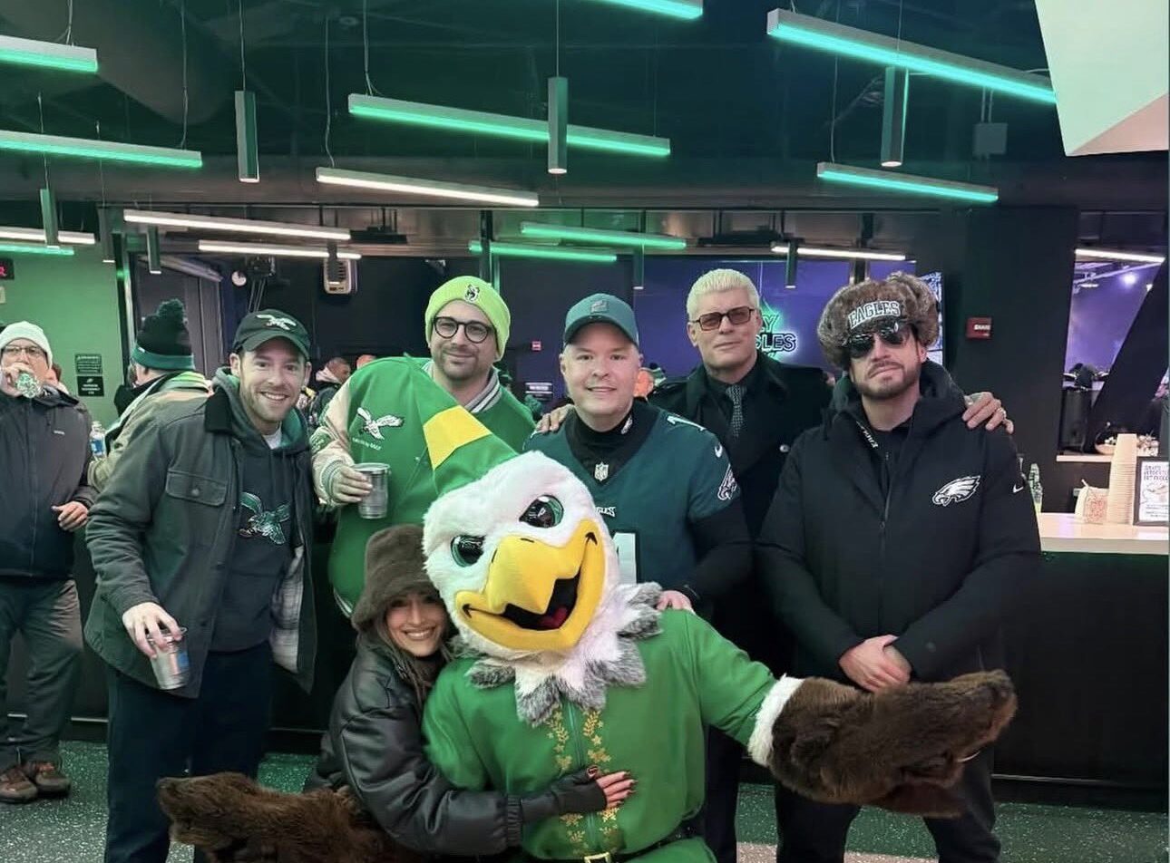 Cody Rhodes and Nikki Bella wearing Philadelphia Eagles gear while cheering in the stands at Lincoln Financial Field.