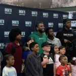 Jaden Hardy smiling while helping kids shop during a holiday event