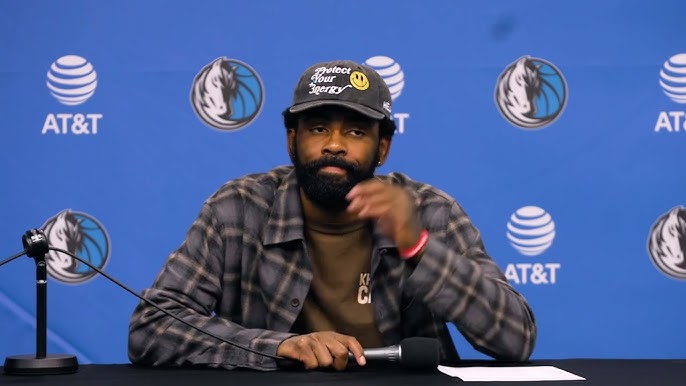 Kyrie Irving watches Dallas Mavericks teammates test drive custom golf carts during a holiday team gift moment.