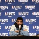 Kyrie Irving at a music event holding a copy of LaRussell’s new album.