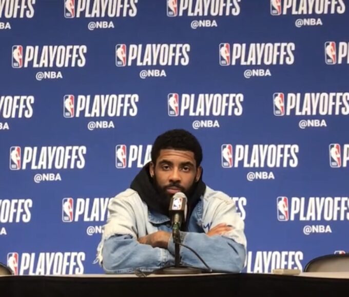 Kyrie Irving at a music event holding a copy of LaRussell’s new album.