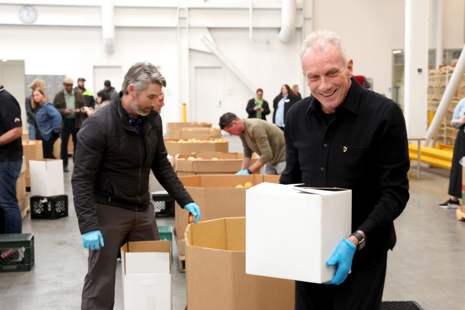 Joe Montana volunteering with Guinness team at SF-Marin Food Bank repacking meals