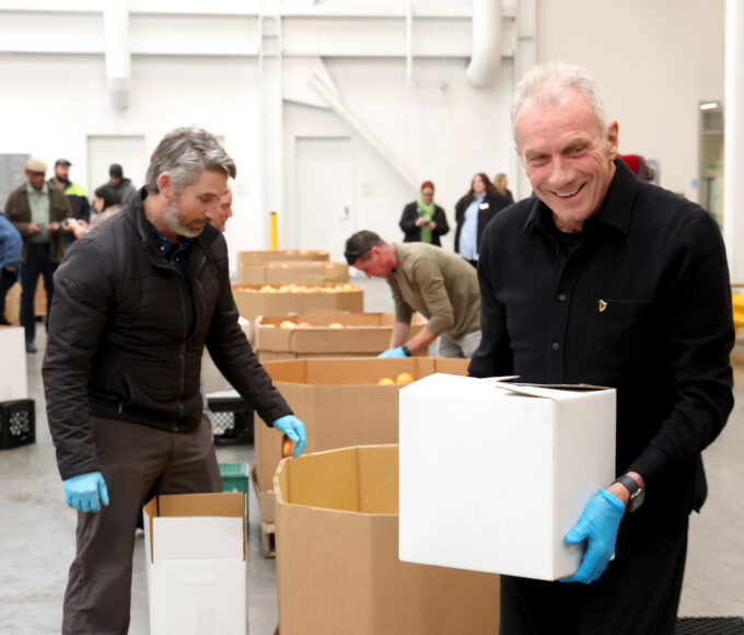 Joe Montana volunteering with Guinness team at SF-Marin Food Bank repacking meals
